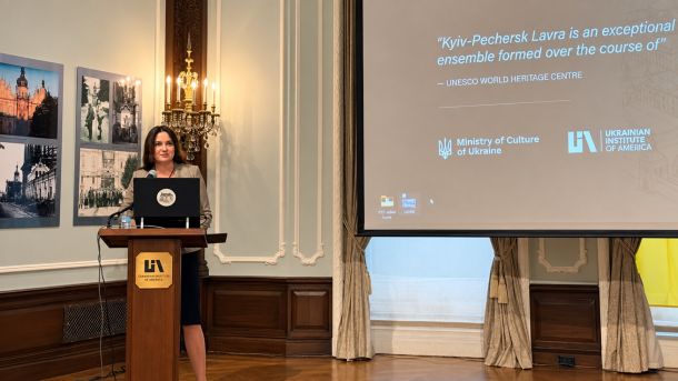 Леся Яструбецька виступає за трибуною Українського інституту Америки на тлі екрана з цитатою ЮНЕСКО про Києво-Печерську Лавру