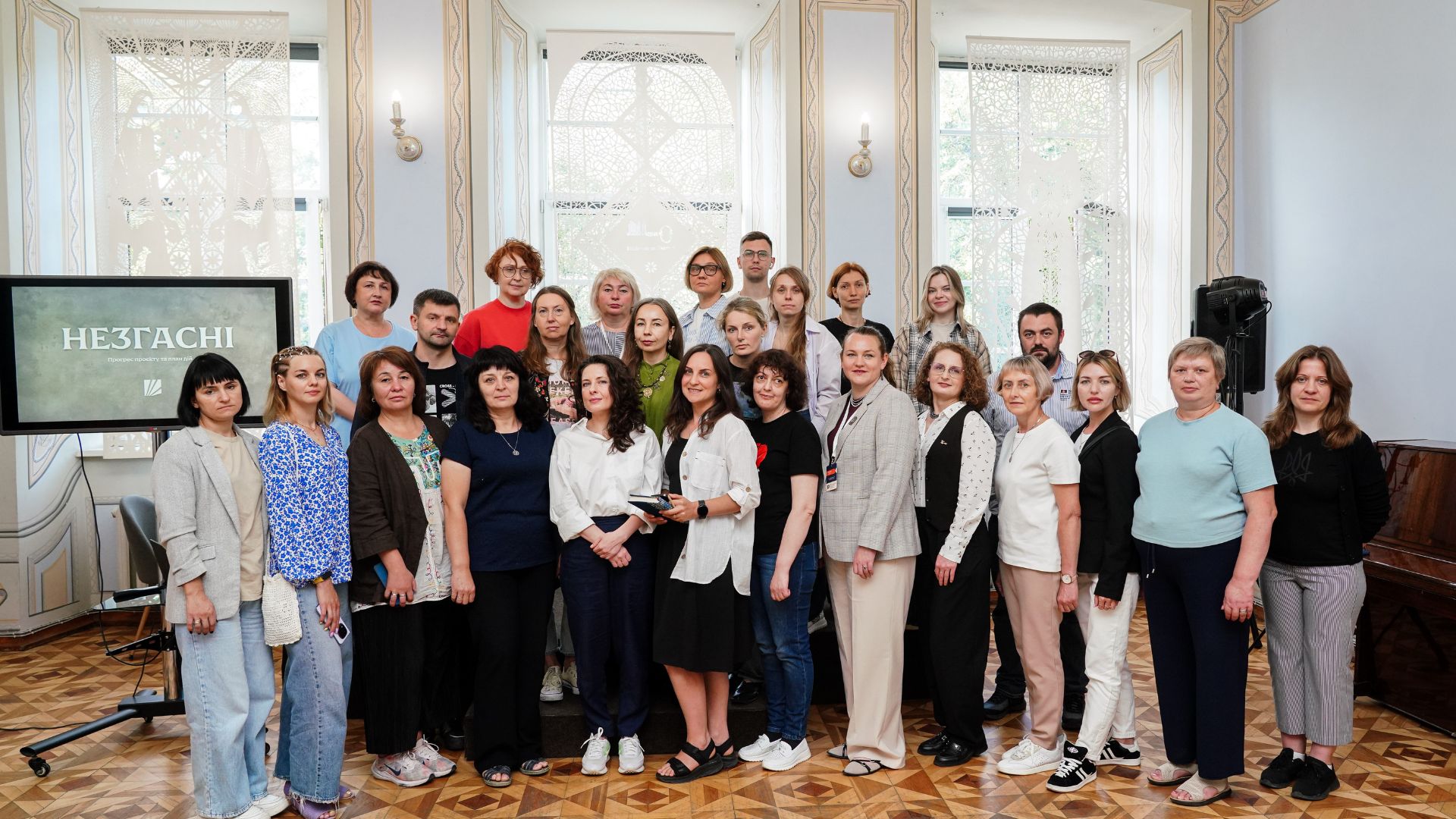 Спільне фото учасників Літньої школи на тлі презентації проєкту «Незгасні»