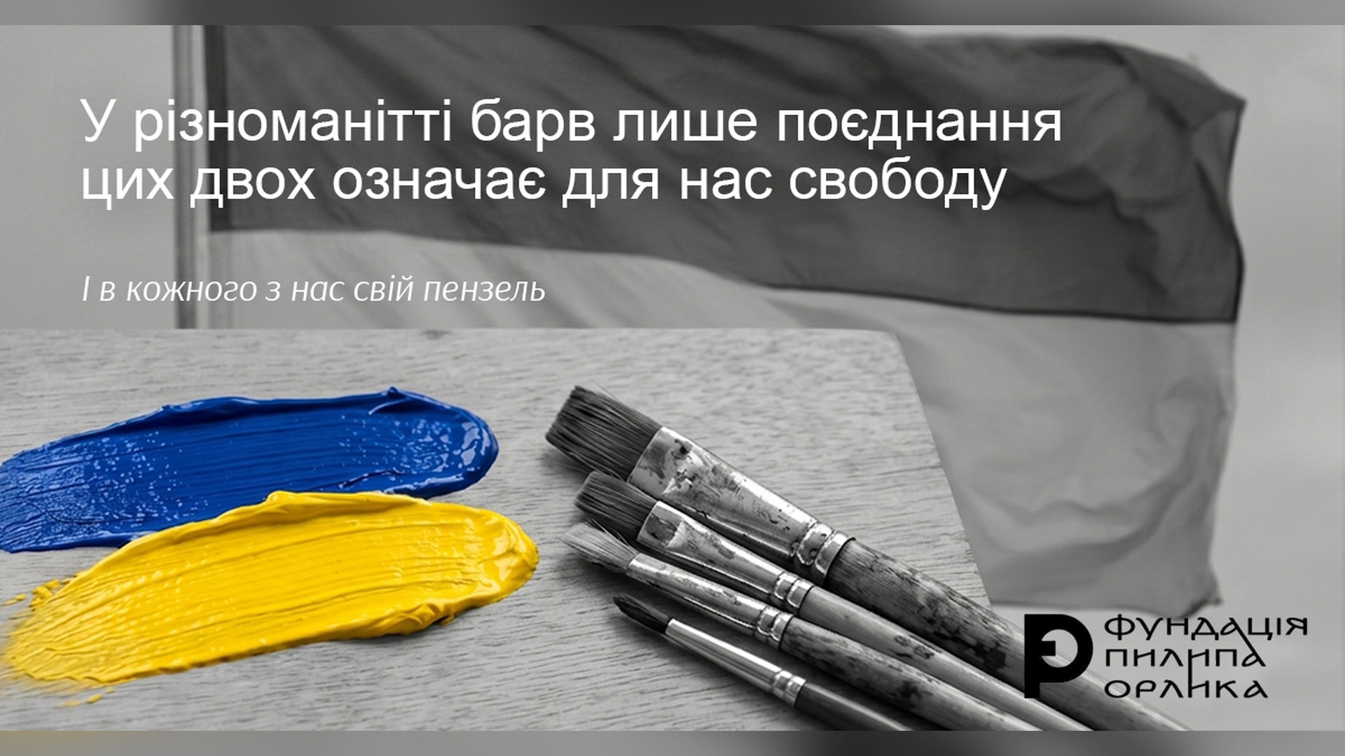 Синьо-жовтий прапор України на тлі мольберта з пензлями та синьою й жовтою фарбою — до Дня Державного Прапора