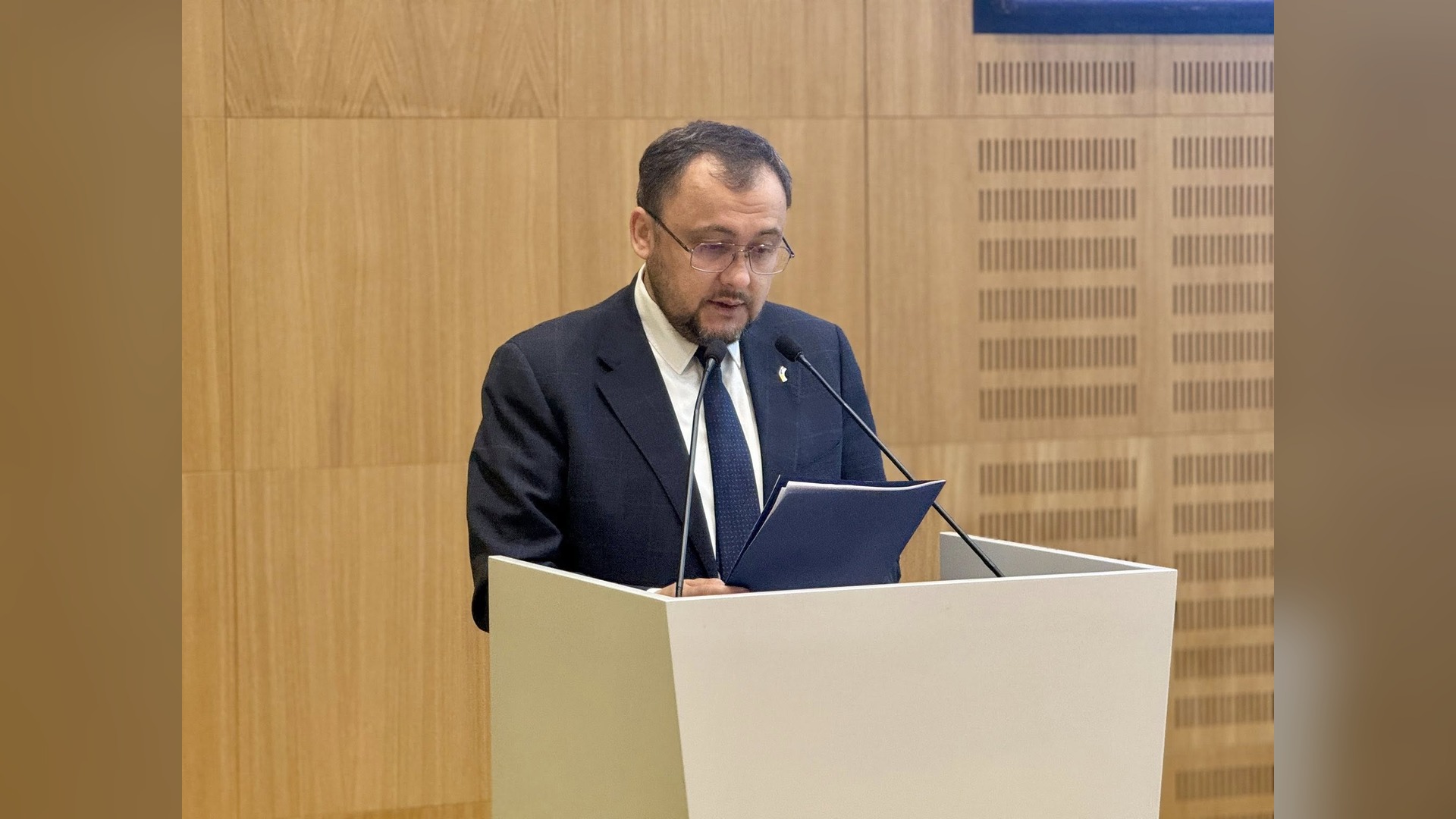 Василь Боднар виступає з трибуни на конференції, читає промову з блокнота