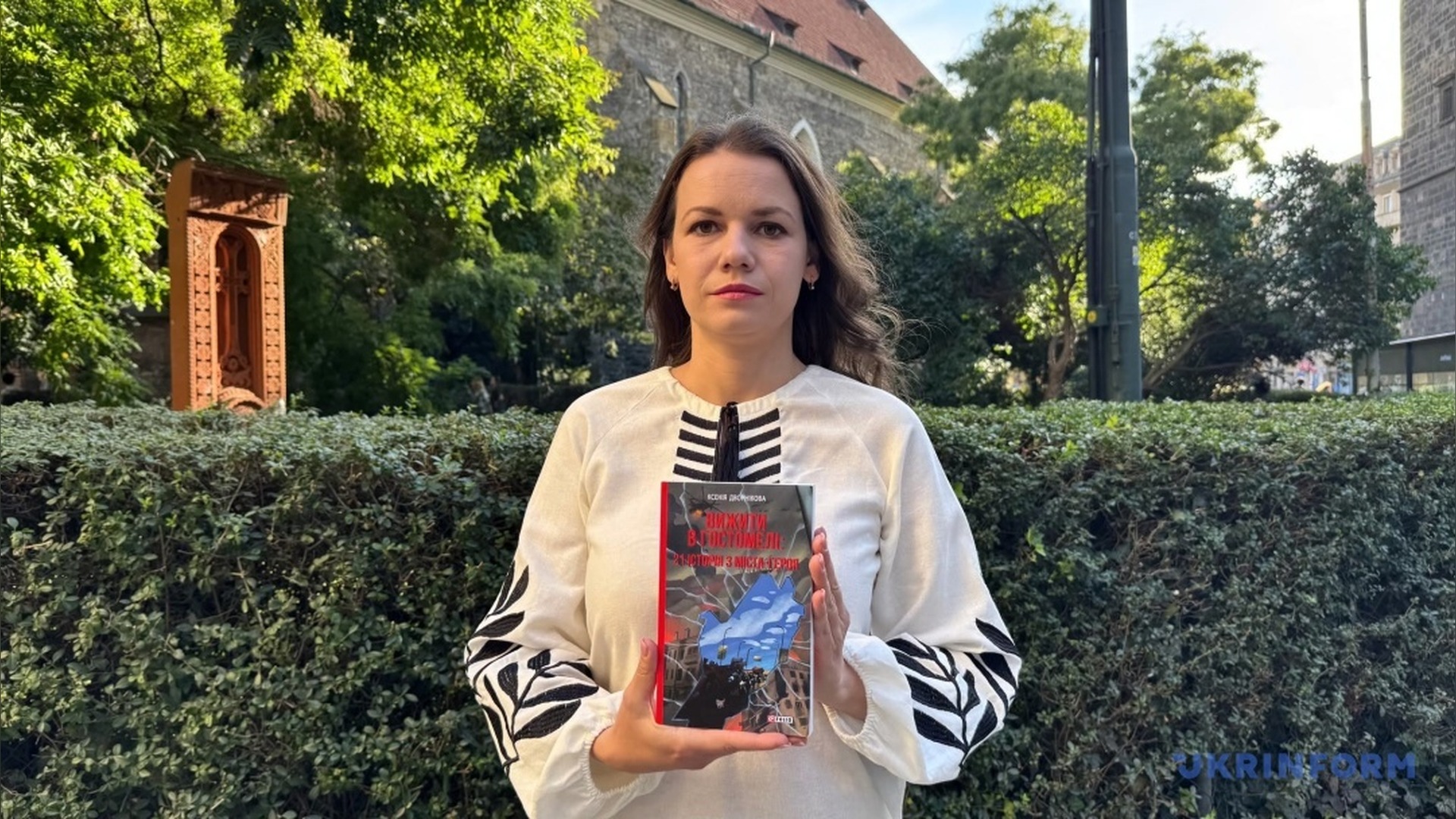 Ксенія Дворнікова тримає книгу «Вижити в Гостомелі: 21 історія з міста-героя» на вулиці в Празі