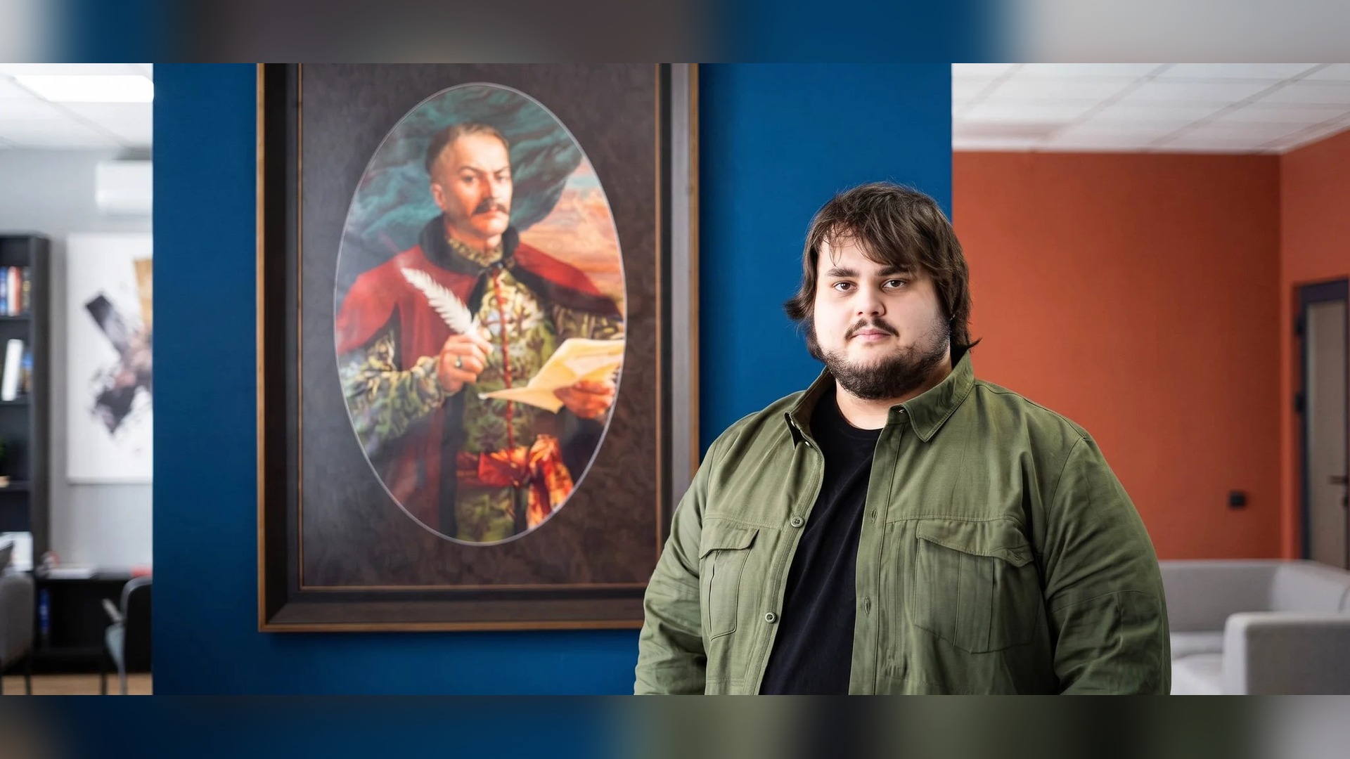 Голова правління Фундації Пилипа Орлика Артем Миколайчук стоїть біля портрета гетьмана Пилипа Орлика в офісі Фундації