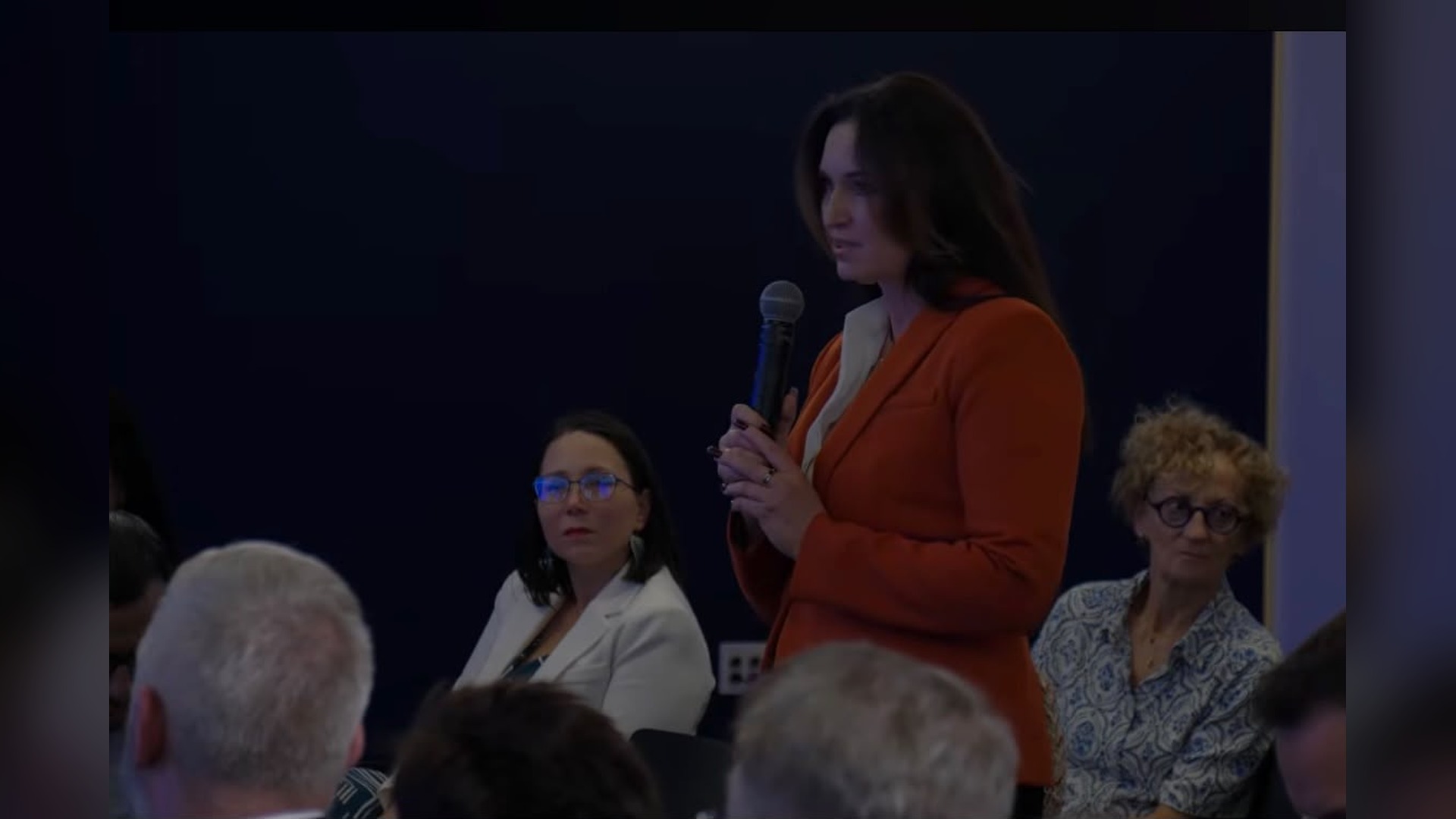 Експертка Фундації Пилипа Орлика Леся Яструбецька з мікрофоном виступає із залу під час дискусії у Чикаго