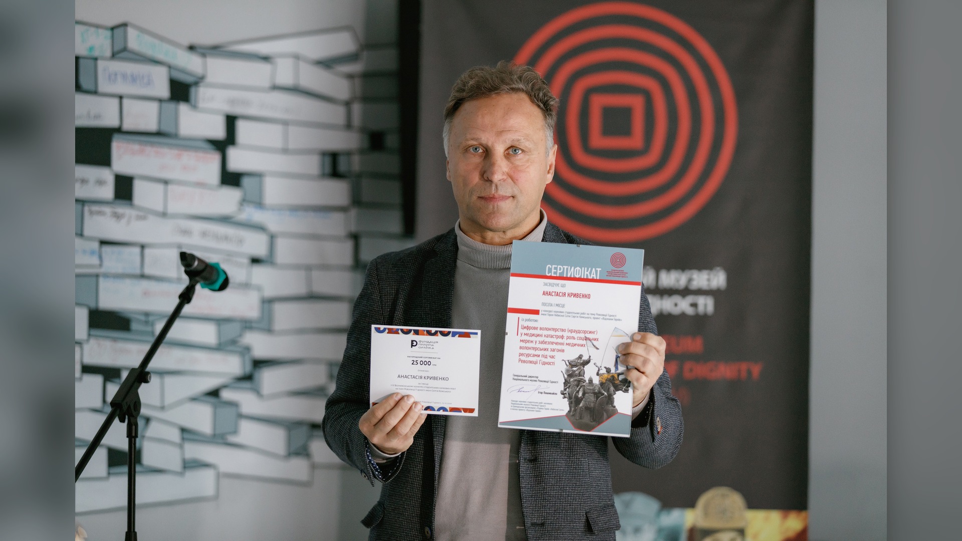 Ihor Poshyvailo with Anastasiia Kryvenko's certificates for first place in the Serhii Kemskyi competition