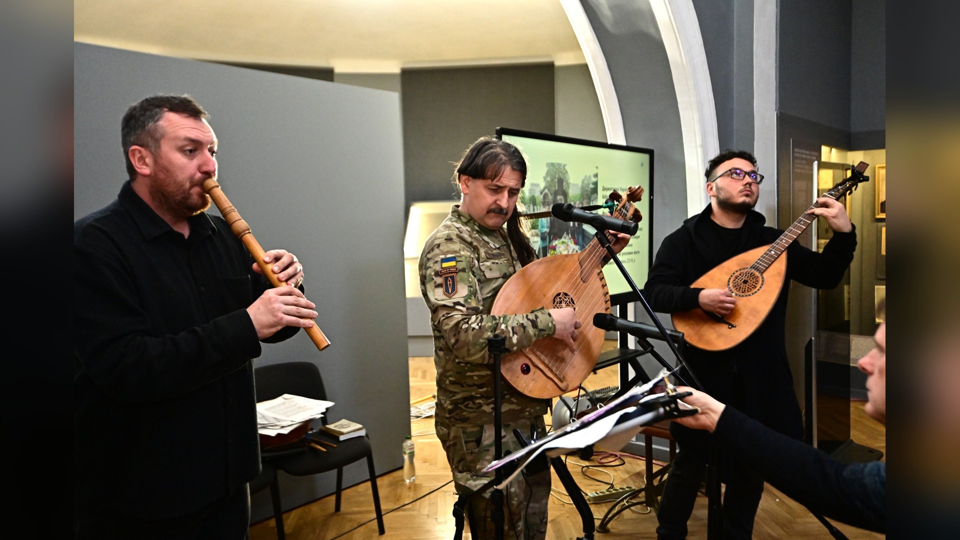 Музиканти гурту «Хорея Козацька» грають на сопілці, кобзі та лютні у залі виставки «Шлях Героїв. Пам’яті Симона Петлюри»