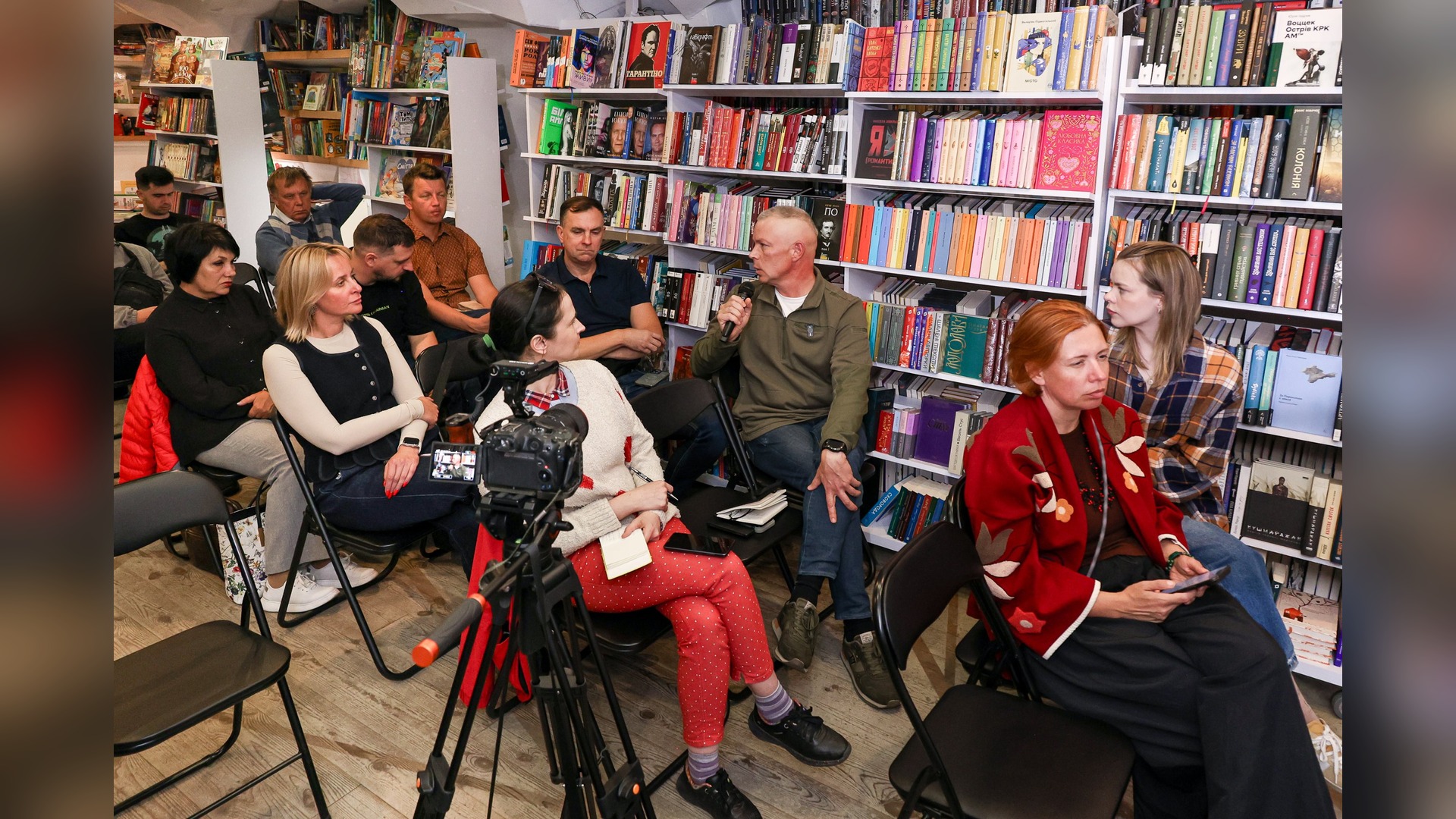 Mykhailo Zabrodskyi speaks with a microphone among the audience at the Kyiv presentation of the book Beast in the Machine