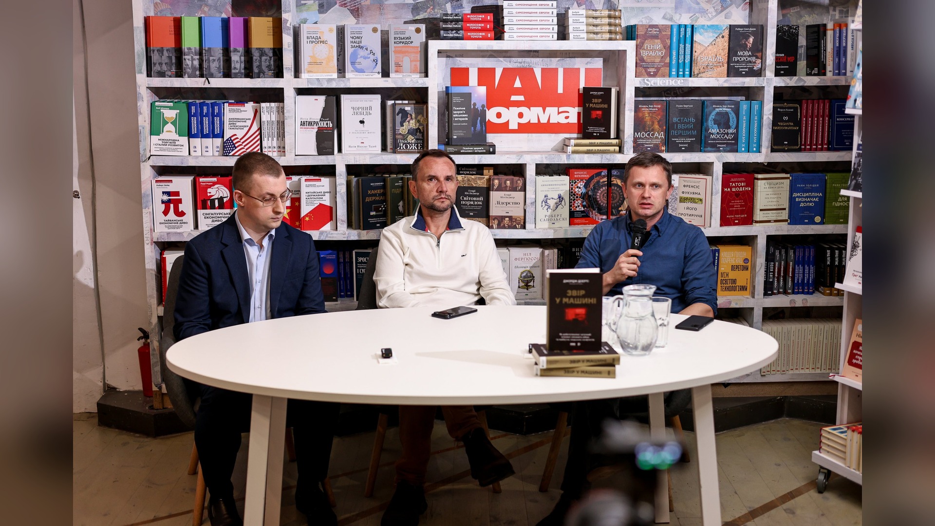 Oleh Zaiarnyi, Volodymyr Viatrovych and Dmytro Rudenko at the table during the presentation of the book Beast in the Machine in a bookstore