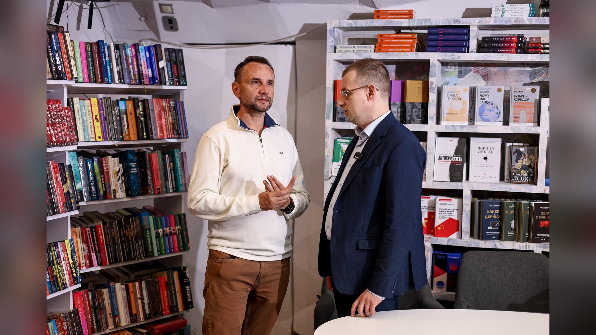 Oleh Zaiarnyi and Volodymyr Viatrovych talk by the bookshelves at the Kyiv presentation of the book Beast in the Machine
