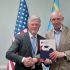 Постійний представник України при ООН Андрій Мельник та посол Ігор Харченко тиснуть руку у Нью-Йорку на фоні прапорів України, США та ООН