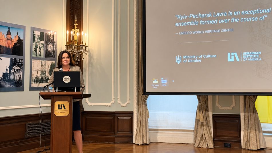Леся Яструбецька виступає за трибуною Українського інституту Америки на тлі екрана з цитатою ЮНЕСКО про Києво-Печерську Лавру