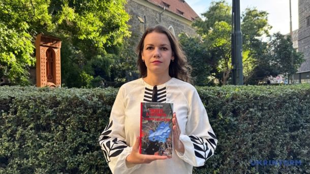 Ксенія Дворнікова тримає книгу «Вижити в Гостомелі: 21 історія з міста-героя» на вулиці в Празі