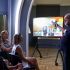Олександр Кучерук виступає перед вчителями історії з лекцією про Євгена Коновальця на тлі екрана з архівними фото
