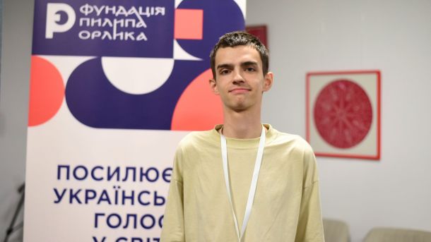 Михальчин Мирослав Андрійович, студент НаУКМА, на фоні банера Фундації Пилипа Орлика