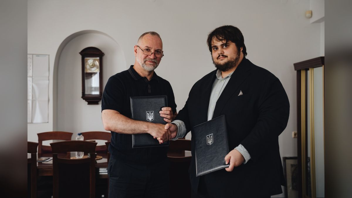Представники Фундації Пилипа Орлика та Національного заповідника «Києво-Печерська лавра» тиснуть руки, тримаючи папки з гербом України, під час підписання меморандуму про співпрацю
