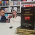 Троє учасників презентації за столом у книгарні, на передньому плані — книга Джорджа Доерті «Звір у машині»