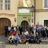 Група учасників менторської програми «Корені та крила» стоїть і сидить перед історичною будівлею Nejmenší dům у Празі